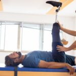 Fizjoterapeuta pomaga pacjentowi po amputacji w ćwiczeniach rehabilitacyjnych