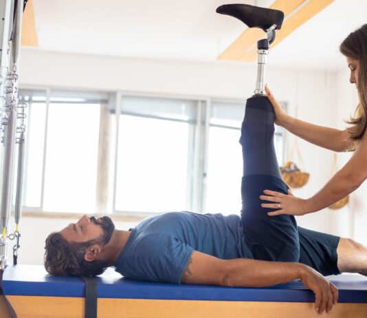 Jak wybrać kurs dla fizjoterapeutów, który realnie podniesie skuteczność terapii w gabinecie Fizjoterapeuta pomaga pacjentowi po amputacji w ćwiczeniach rehabilitacyjnych