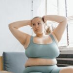 Plus size kobieta w turkusowym stroju relaksuje się przy oknie