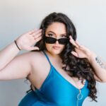 Pewna siebie kobieta plus size w niebieskim stroju kąpielowym i okularach