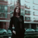 Pewna siebie młoda kobieta w eleganckim stroju na miejskiej ulicy