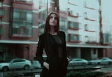Pewna siebie młoda kobieta w eleganckim stroju na miejskiej ulicy