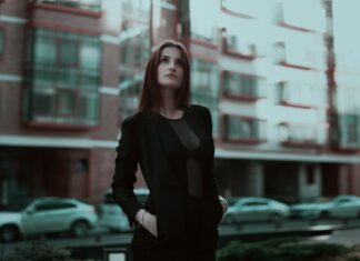 Pewna siebie młoda kobieta w eleganckim stroju na miejskiej ulicy