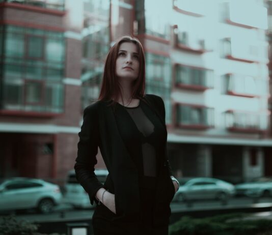 Pewna siebie młoda kobieta w eleganckim stroju na miejskiej ulicy