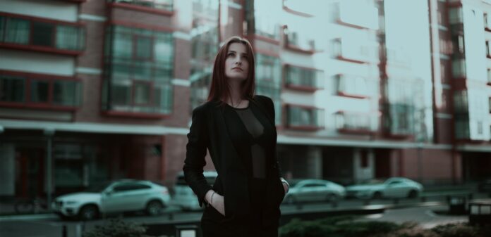 Pewna siebie młoda kobieta w eleganckim stroju na miejskiej ulicy Pewna siebie młoda kobieta w eleganckim stroju na miejskiej ulicy